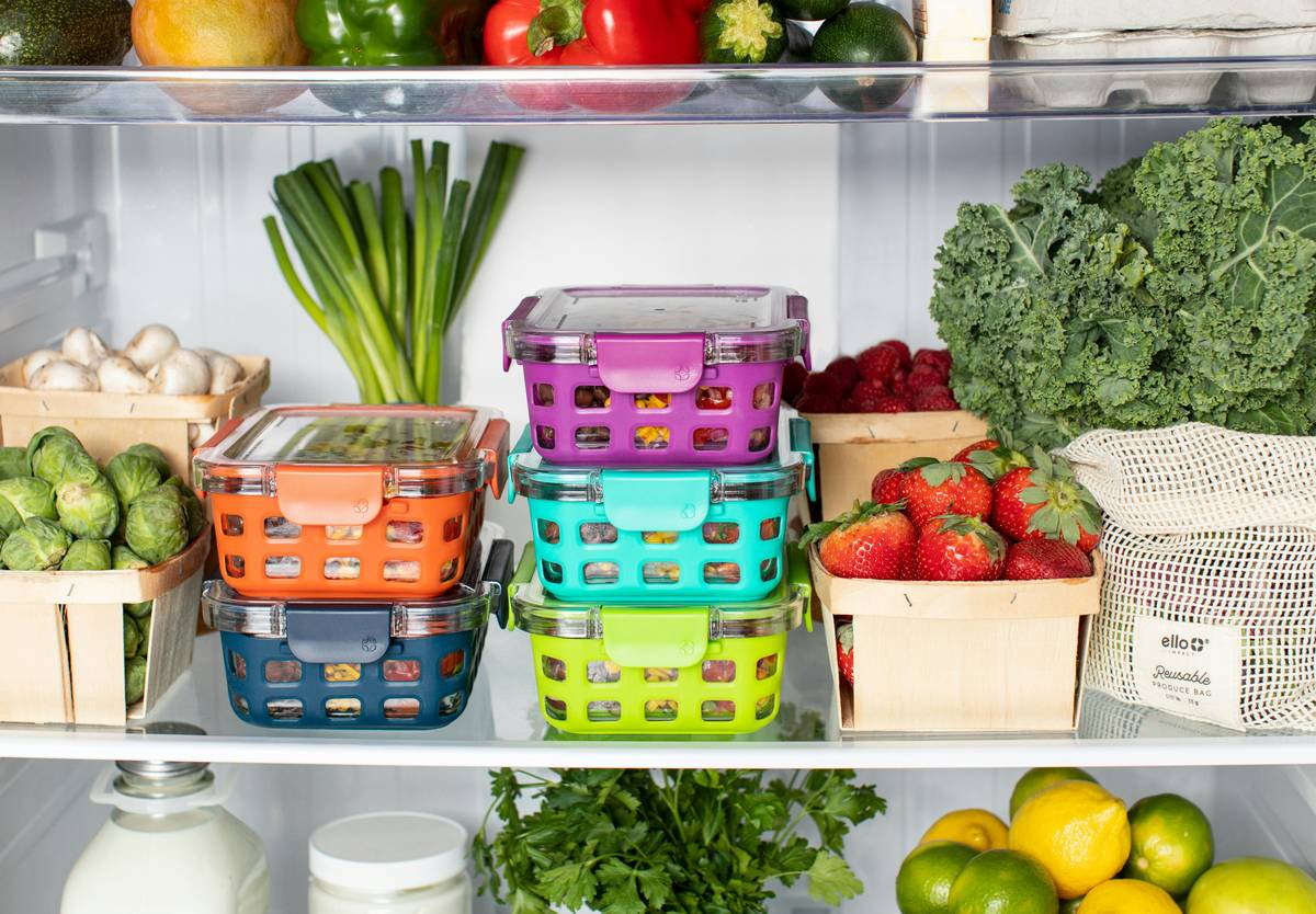 Reusable silicone food storage bags arranged neatly in a kitchen drawer next to fresh produce — sustainable food storage solutions
